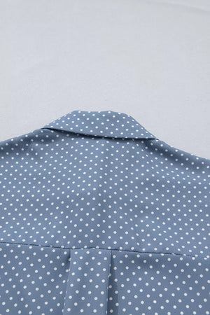 Blue polka dot polyester shirt with a collared neckline and subtle pleating detail.