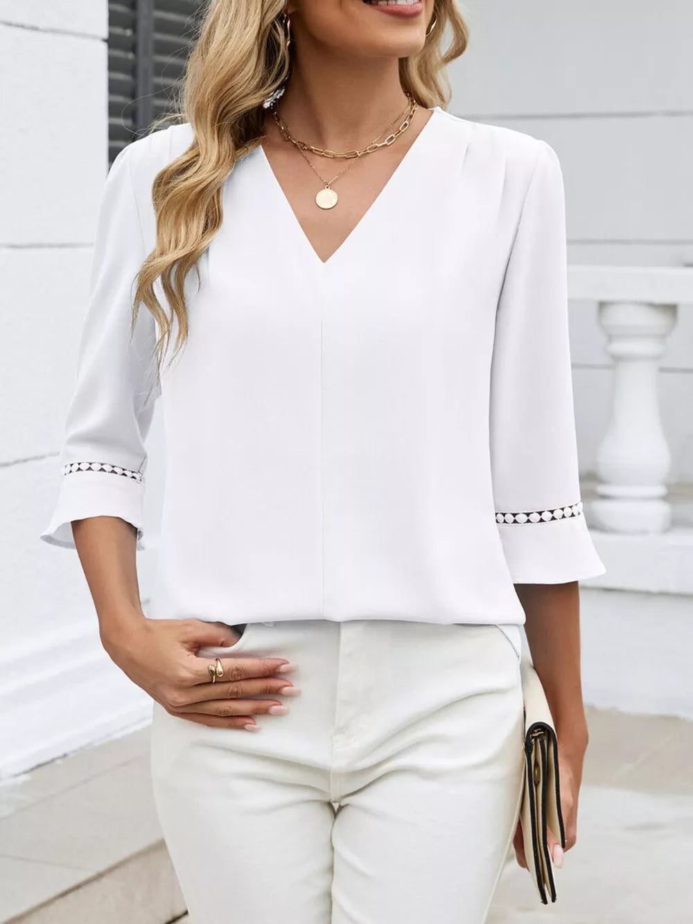 White V-neck blouse with 3/4 sleeves featuring lace trim detail at the cuffs.