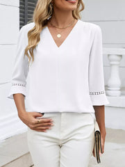 White V-neck blouse with 3/4 sleeves featuring lace trim detail at the cuffs.
