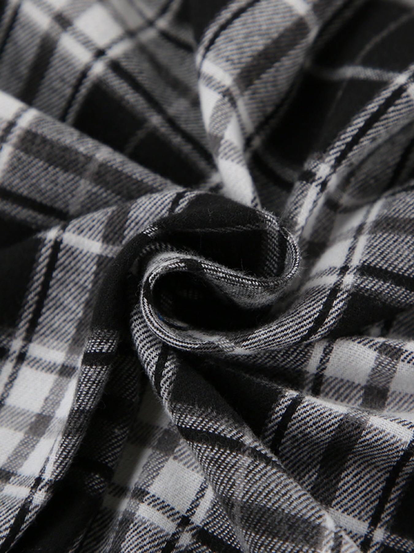 Oversized button-up shirt in black and white plaid cotton fabric.