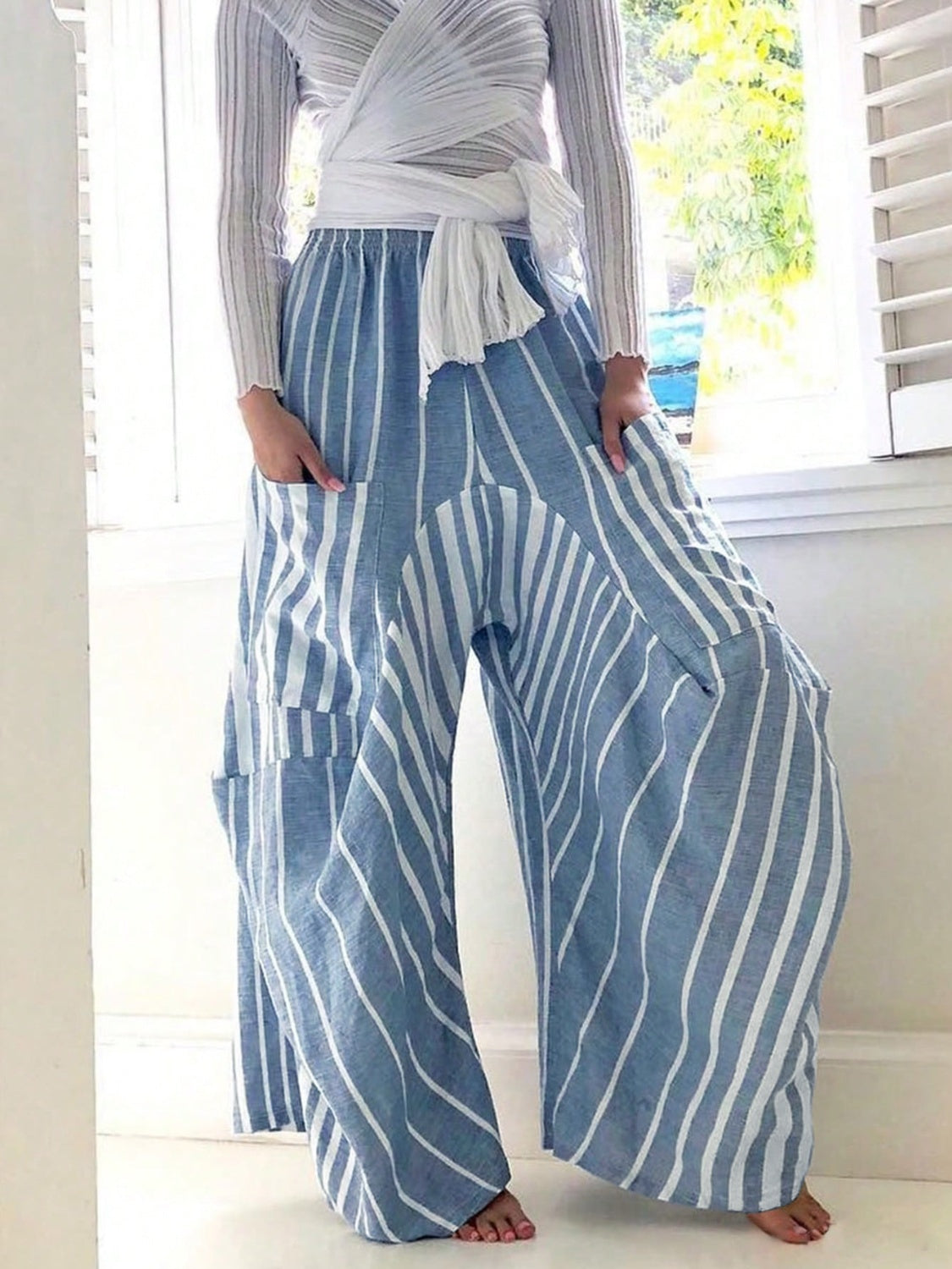 Light blue and white striped palazzo trousers with patch pockets and wide legs.