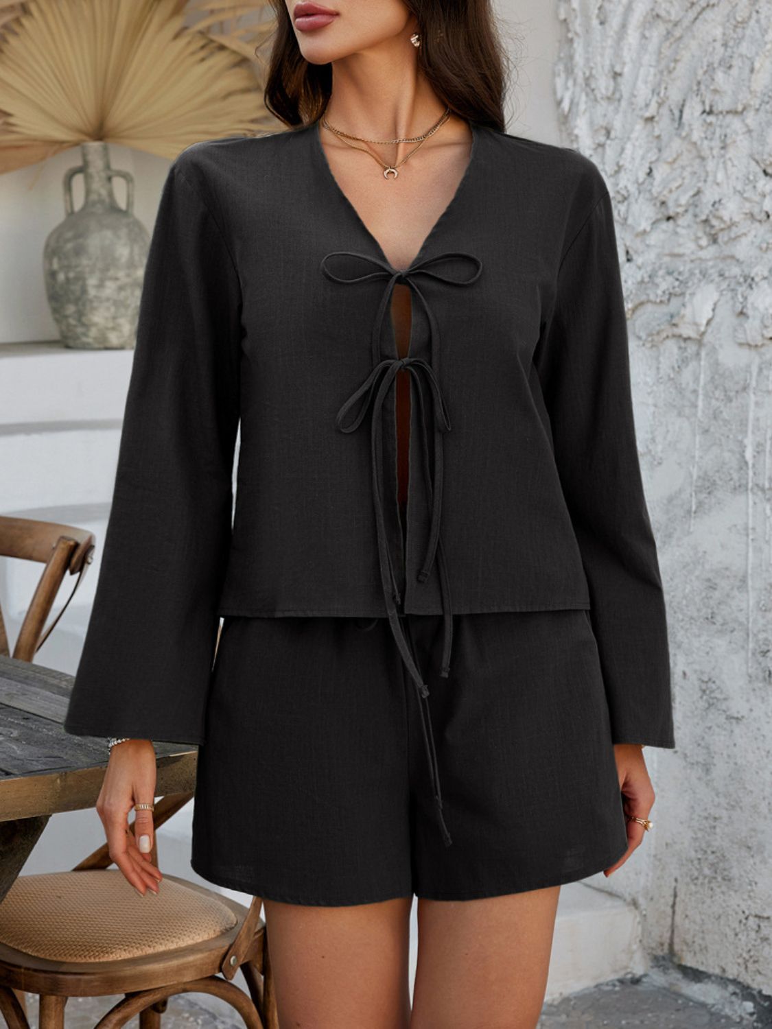 Black linen tie-front top and shorts set with flared sleeves.