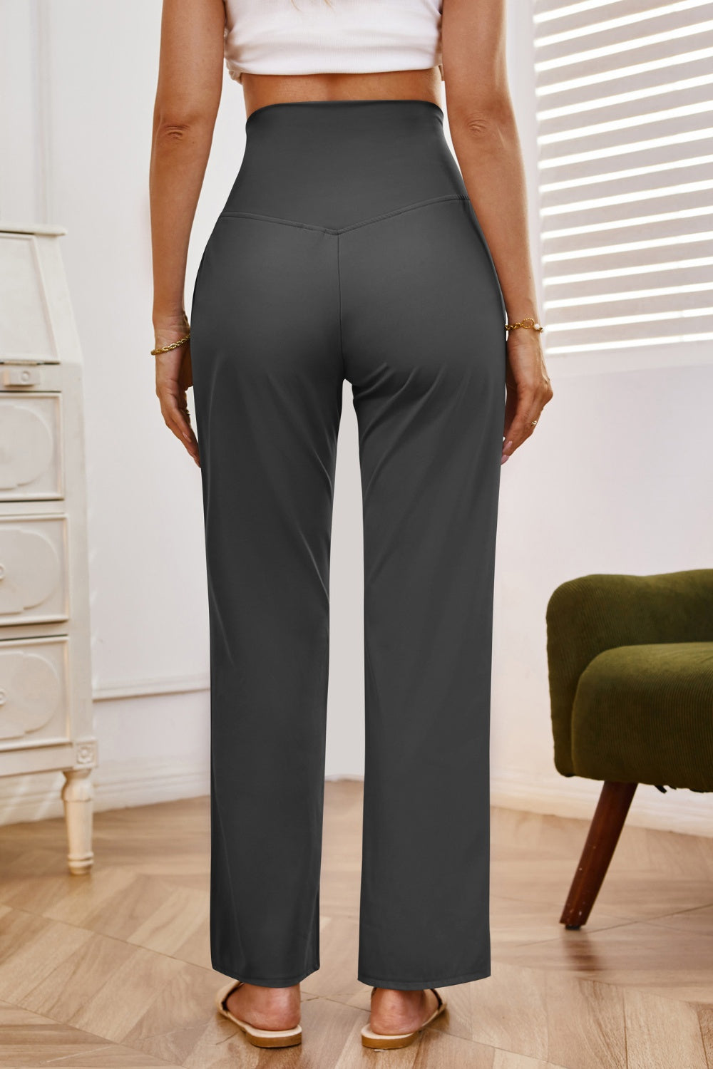 High-waisted flare leg trousers in dark gray with a V-shaped waistband detail.