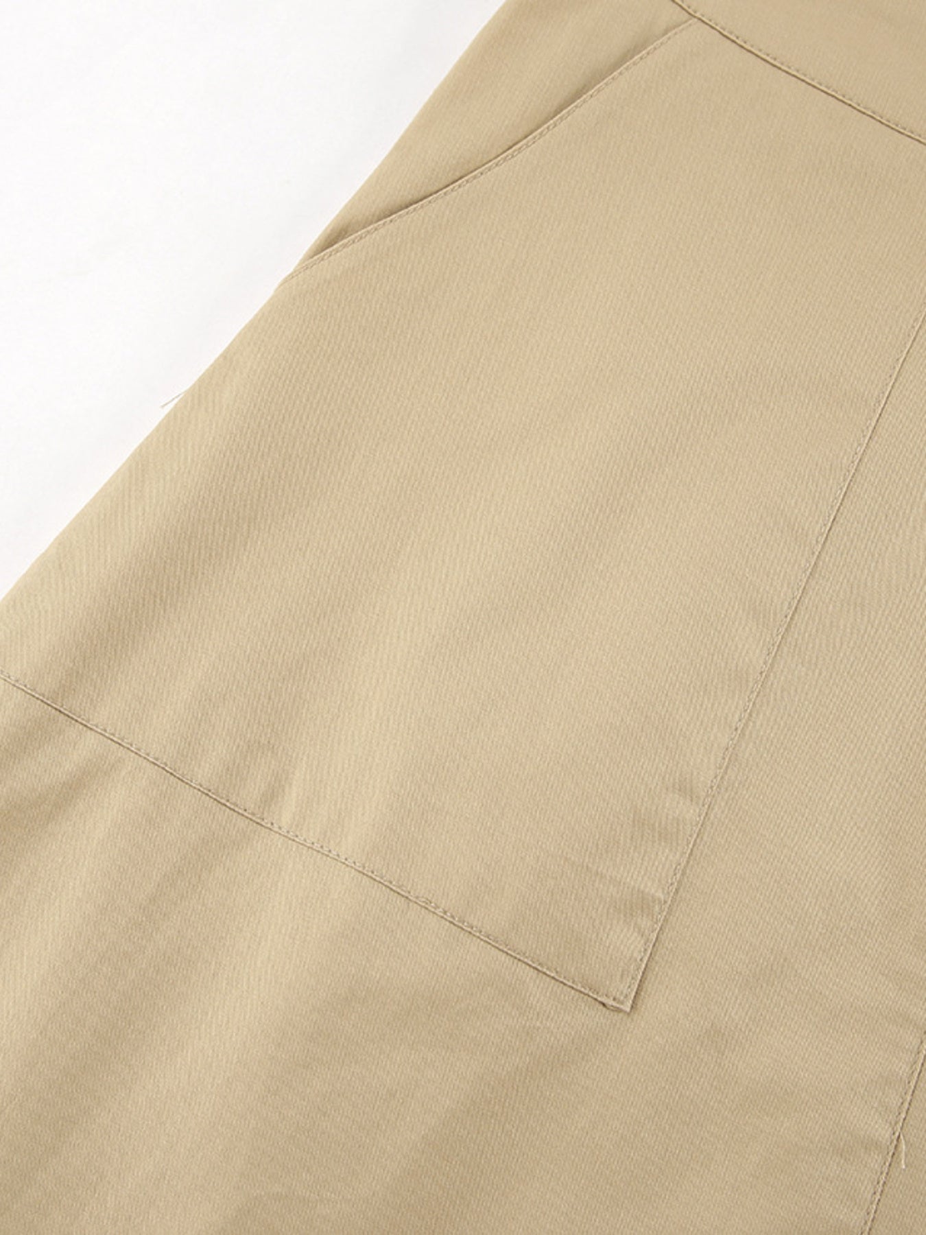 Beige cotton A-line skirt with large front pockets and visible stitching details.