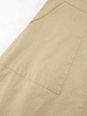 Beige cotton A-line skirt with large front pockets and visible stitching details.