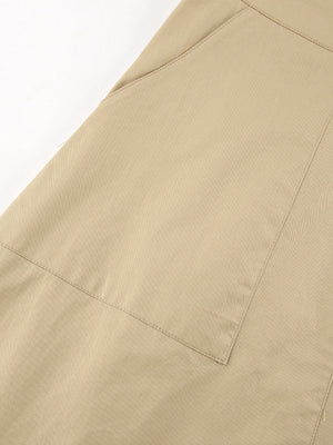 Beige cotton A-line skirt with large front pockets and visible stitching details.