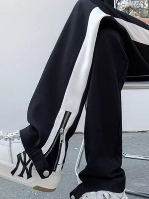 Black sweatpants with white side stripe and ankle zipper detail.
