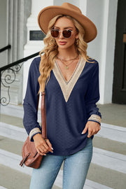 Dark blue textured blouse with crochet V-neck and cuffs, long sleeves.