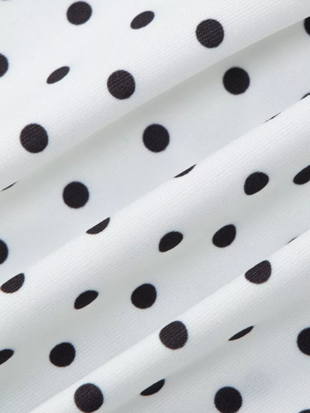 White t-shirt with black polka dots and ruched fabric detail.