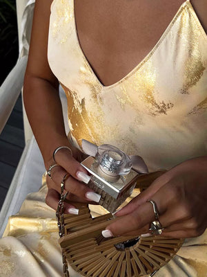 Cream v-neck maxi gown with abstract gold pattern, backless detail.