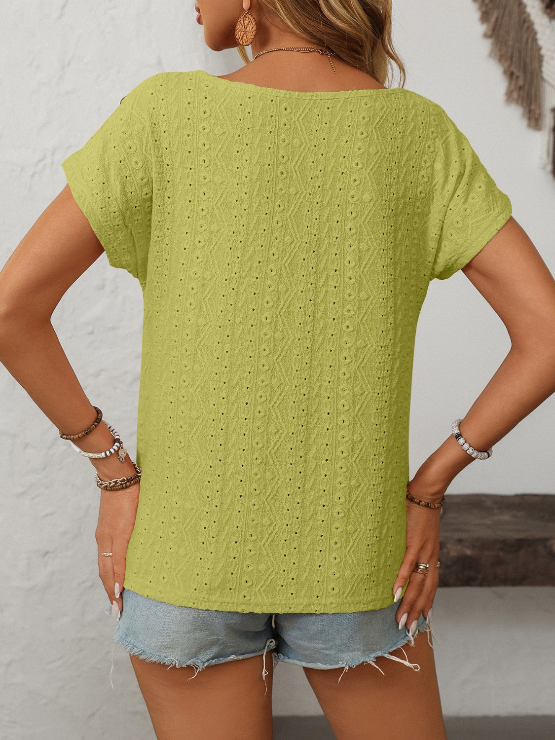 Yellow-Green eyelet knit tee with short sleeves and a scoop neck, featuring a textured pattern and shoulder buttons.