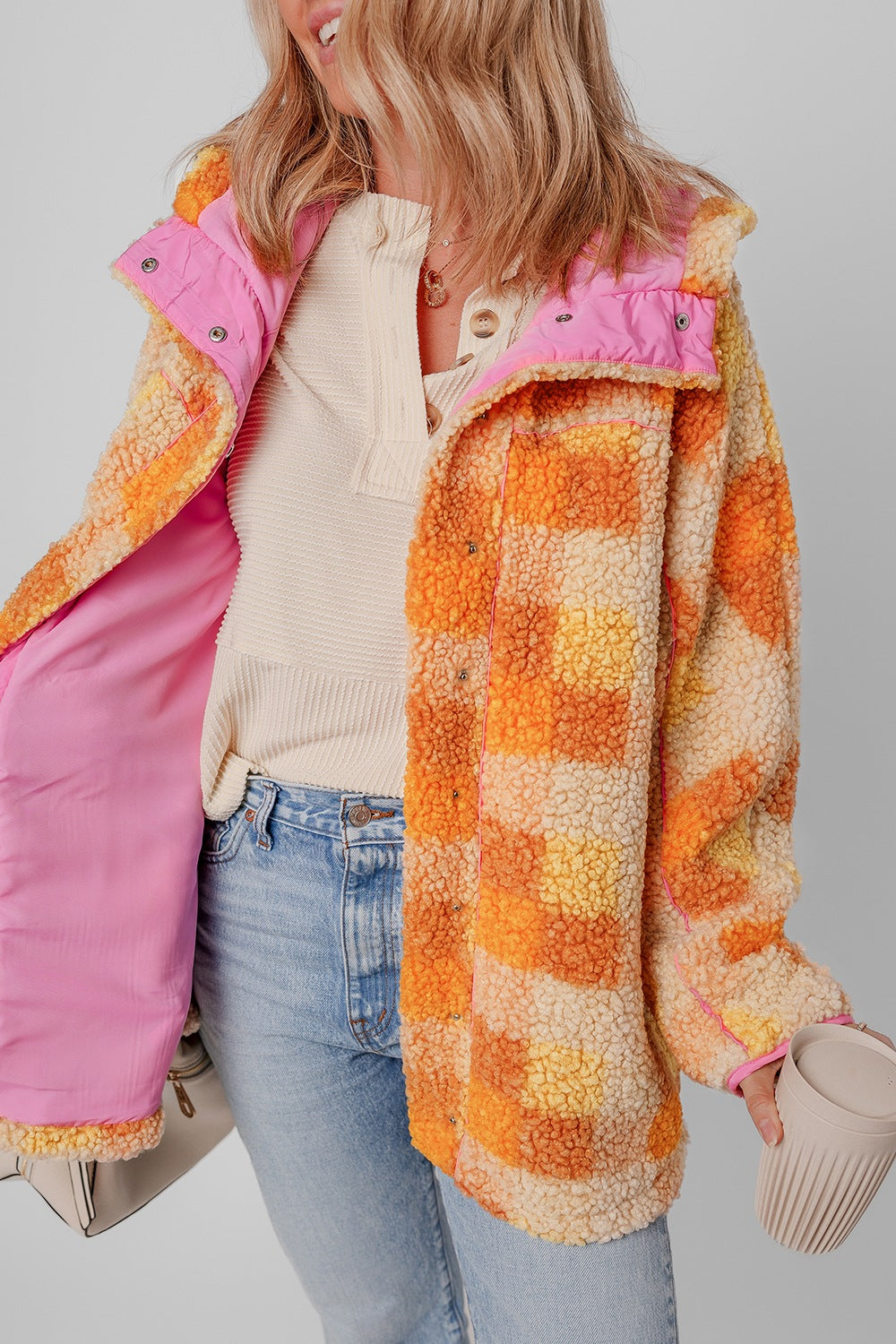 Checkerboard sherpa jacket in tangerine with contrast pink collar and lining.