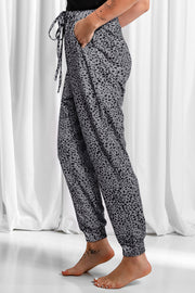 Jogger trousers in dark gray with black leopard print, drawstring waist, and cuffed ankles.
