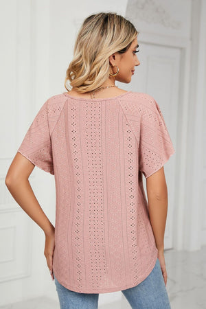 Pink eyelet tie-neck blouse with flutter sleeves and a rounded hem.