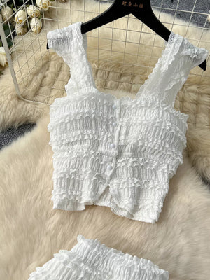 White textured two-piece set with ruffled details, button front, square neck, and cap sleeves.