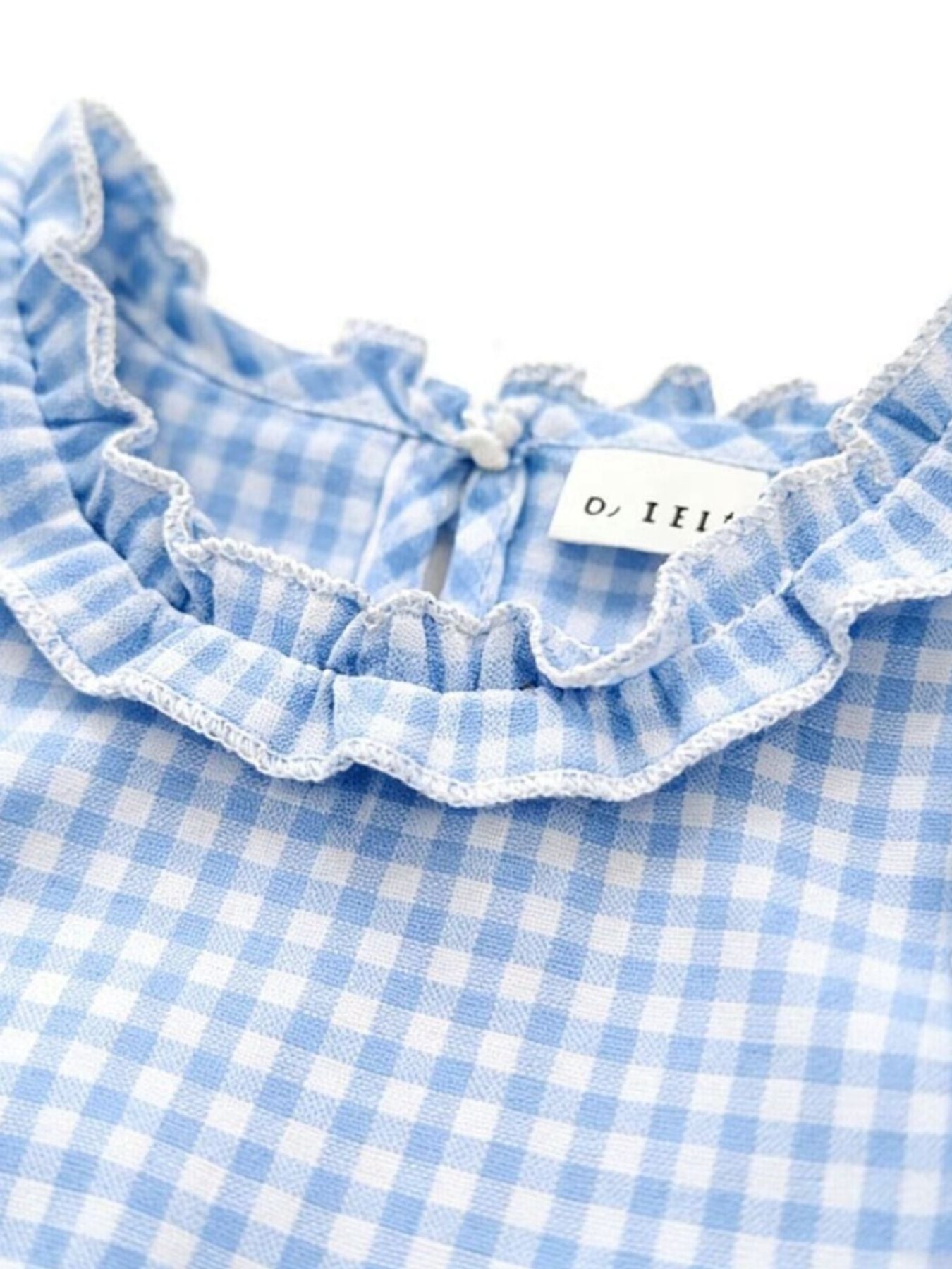 Children's light blue gingham cotton set with ruffled neckline and button closure.