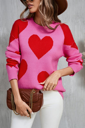 Pink and red heart patchwork knit sweater with crew neck and long sleeves.