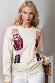 Ivory crewneck sweater with sequin nutcracker embellishments.