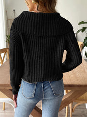 Black ribbed knit sweater with a wide shawl collar and long sleeves.