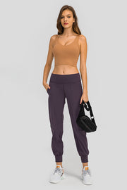 Jogger fit performance trousers in plum purple with pockets and cuffed ankles.