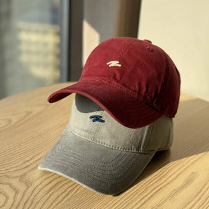 Distressed cotton baseball hats in Wine Red and Dark Gray with embroidered logos.