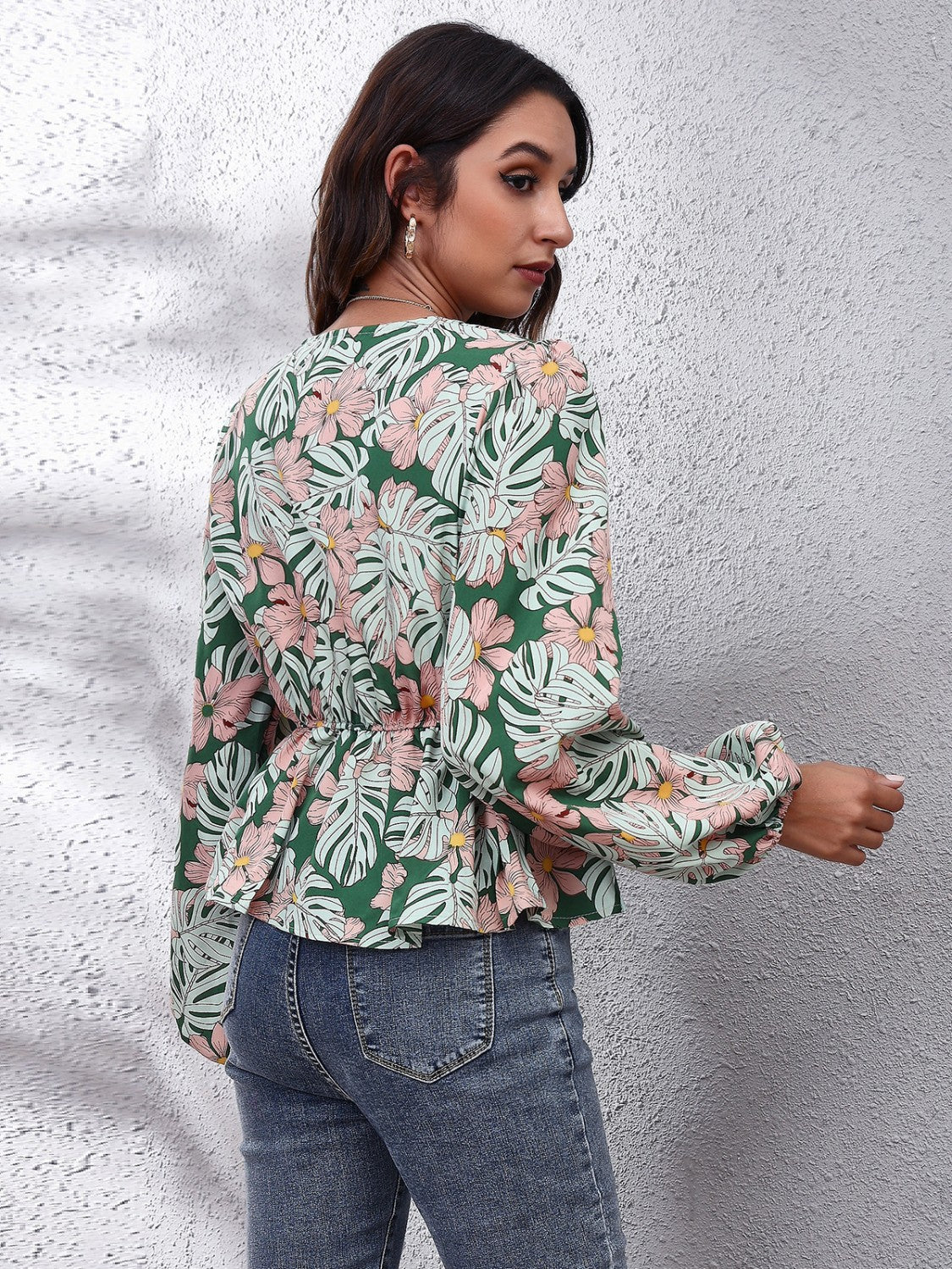Green tropical print peplum blouse with balloon sleeves and cinched waist.