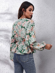 Green tropical print peplum blouse with balloon sleeves and cinched waist.