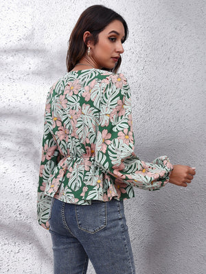 Green tropical print peplum blouse with balloon sleeves and cinched waist.