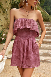 Strapless ruffled romper with floral embroidery and smocked waist.