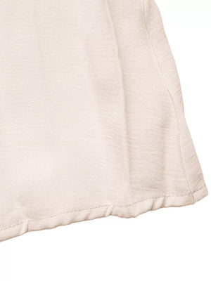 Apricot midi dress with textured fabric and a pleated hem detail.