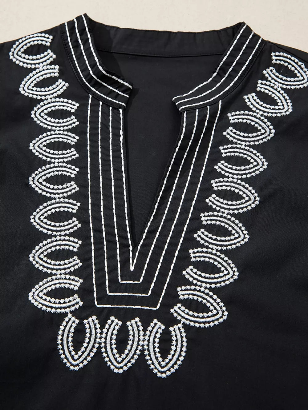 Black maternity overshirt with white embroidery detail on neckline and V-neck.
