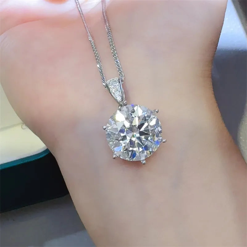 Silver moissanite solitaire pendant with a large round-cut stone and diamond accent bail.