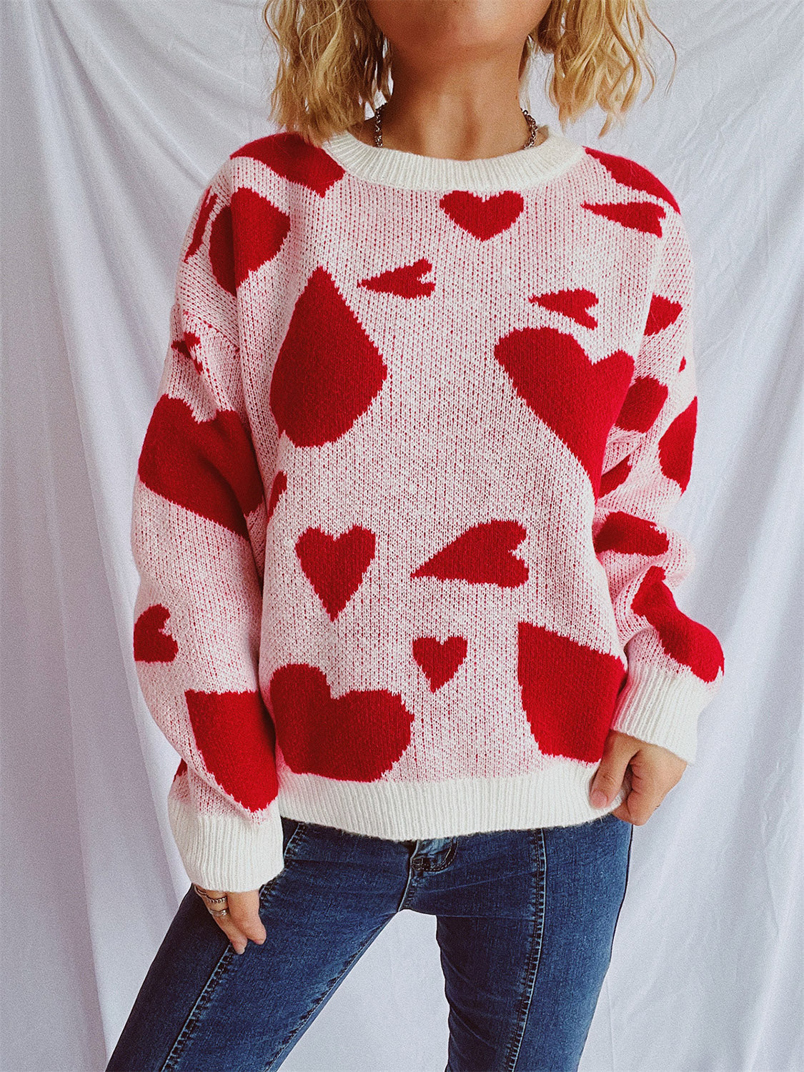 Heart motif knit sweater in pink with red hearts, crew neck, long sleeves, casual style.