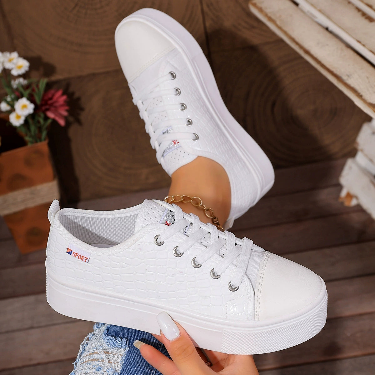 White crocodile embossed platform sneakers with chunky soles and laces.