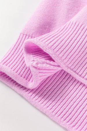 Pink knit sweater with contrast stitching detail on the sleeve cuff.