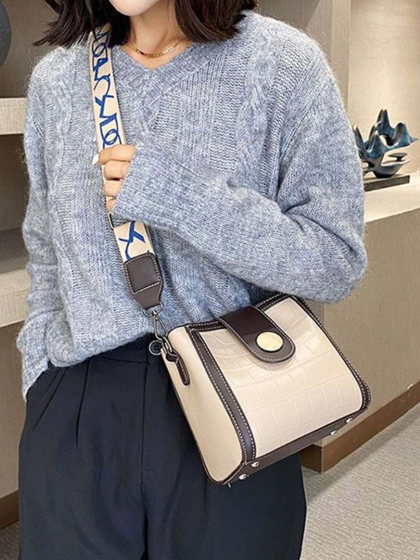 Khaki crocodile pattern mini crossbody bag with brown trim and a patterned strap.