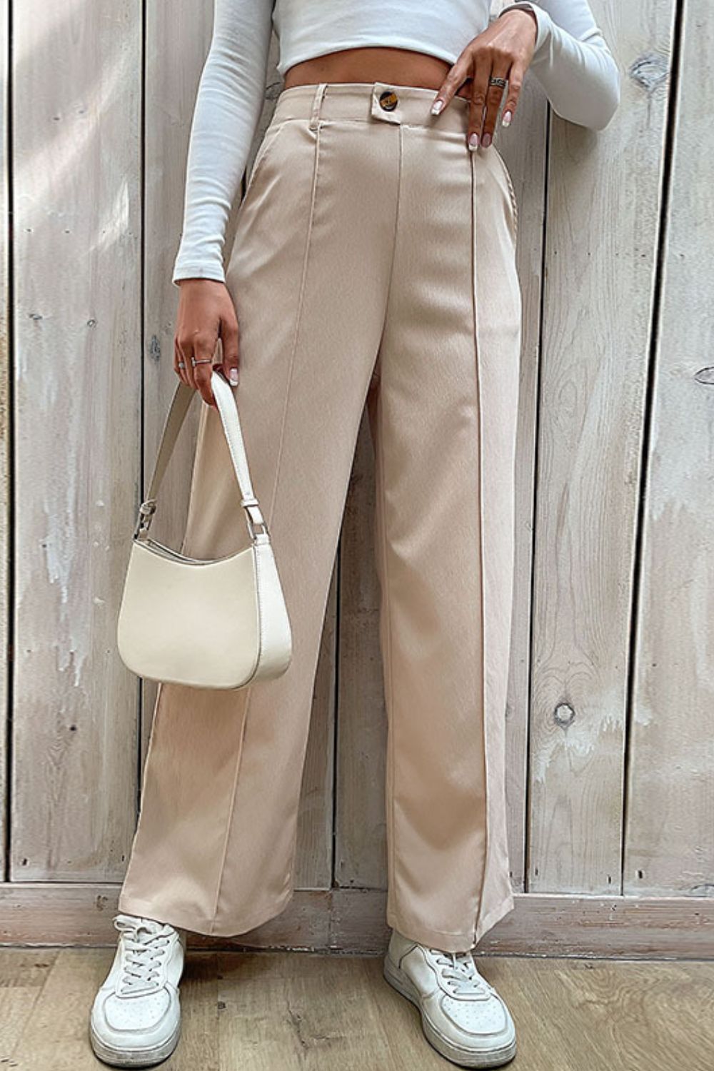 Beige tailored seam wide-leg trousers with a button closure and front pleats.