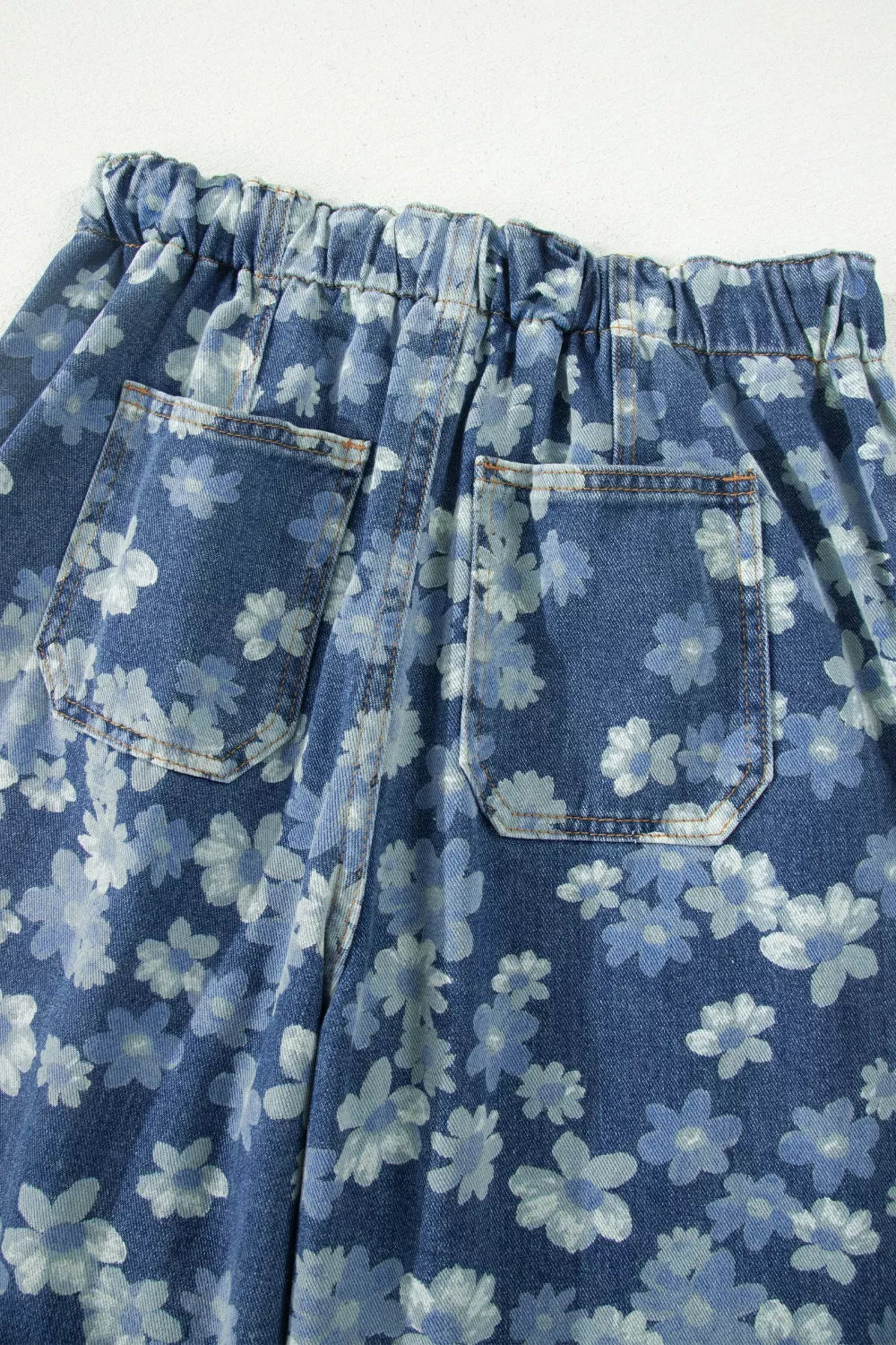 Blue floral denim barrel jeans with pockets and drawstring waist.