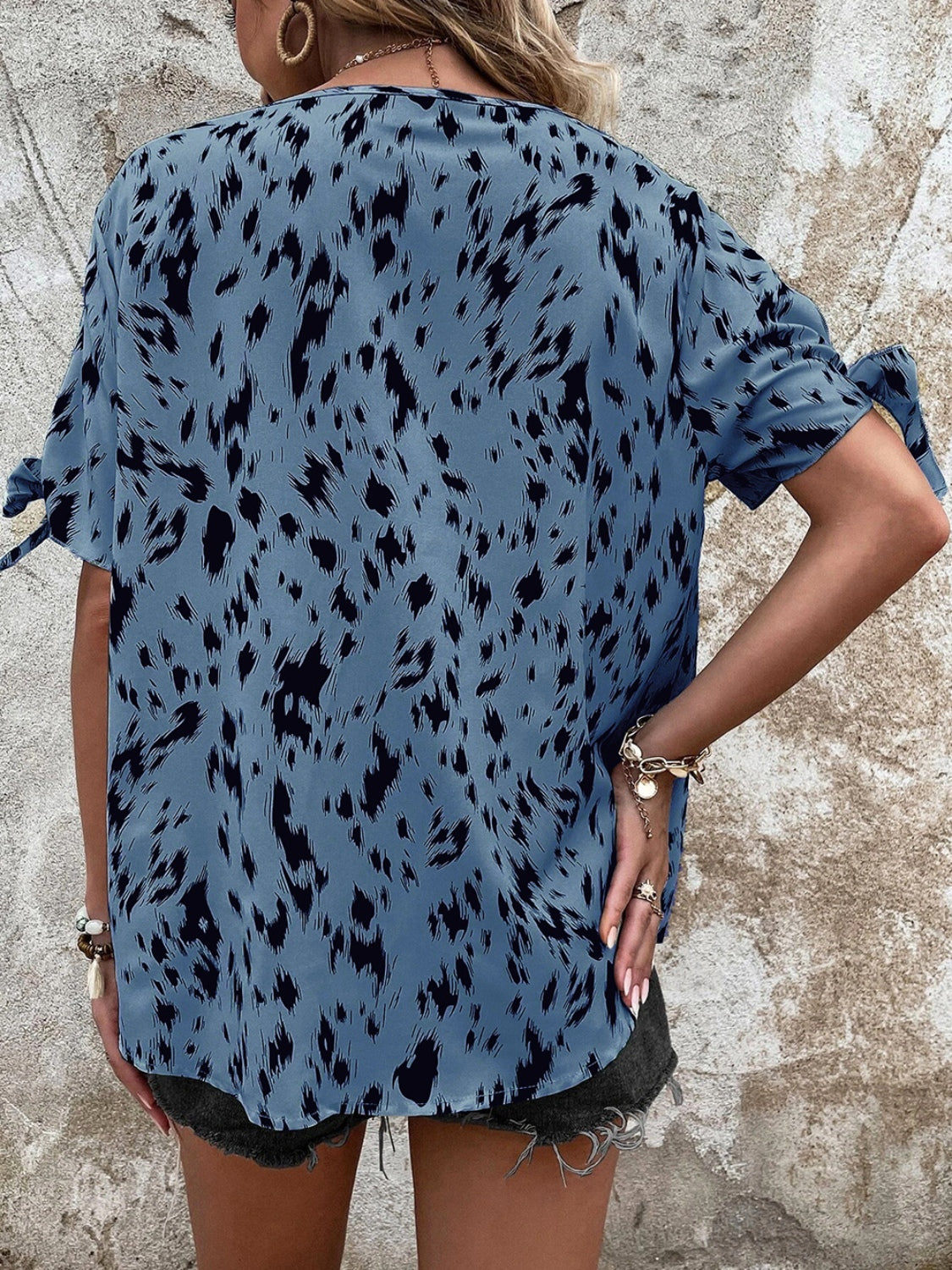 Sky blue Dalmatian print blouse with bow sleeves and a boatneck.