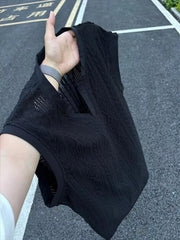 Black textured knit tank top with relaxed V-neck and open weave detail.