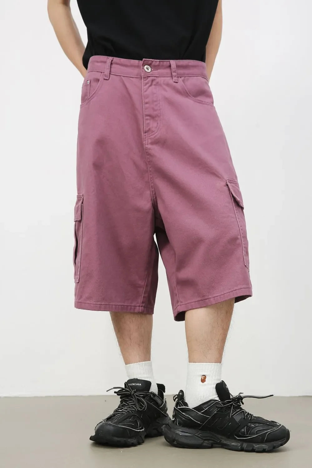 Magenta baggy cargo Bermuda shorts with buttoned front and side pockets.