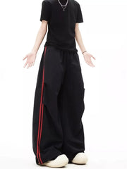 Black wide-leg sweatpants with red side stripes and adjustable drawstring waist.
