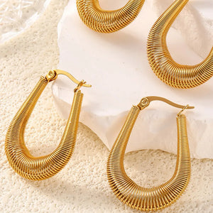 Gold oval hoop earrings with a coiled wire design and secure clasp closure.
