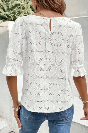 White eyelet lace blouse with puff sleeves and ruffled cuffs.