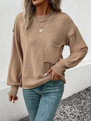 Camel knit sweater with raglan sleeves, a chest pocket, and ribbed cuffs and hem.