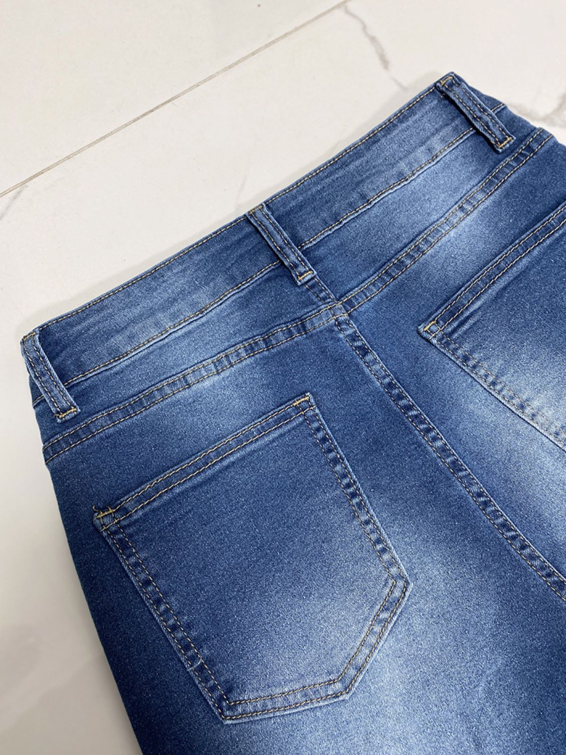 Medium wash denim jeans with contrast stitching and back pockets.