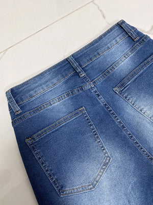 Medium wash denim jeans with contrast stitching and back pockets.