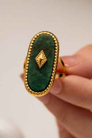 Oval green stone ring with diamond accent and gold-plated beaded detail.