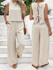 Cream linen lounge set with scalloped hem top and backless bow detail, wide leg pants.