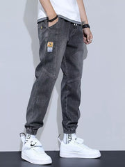 Gray jogger jeans with drawstring, pockets, and patch detail.